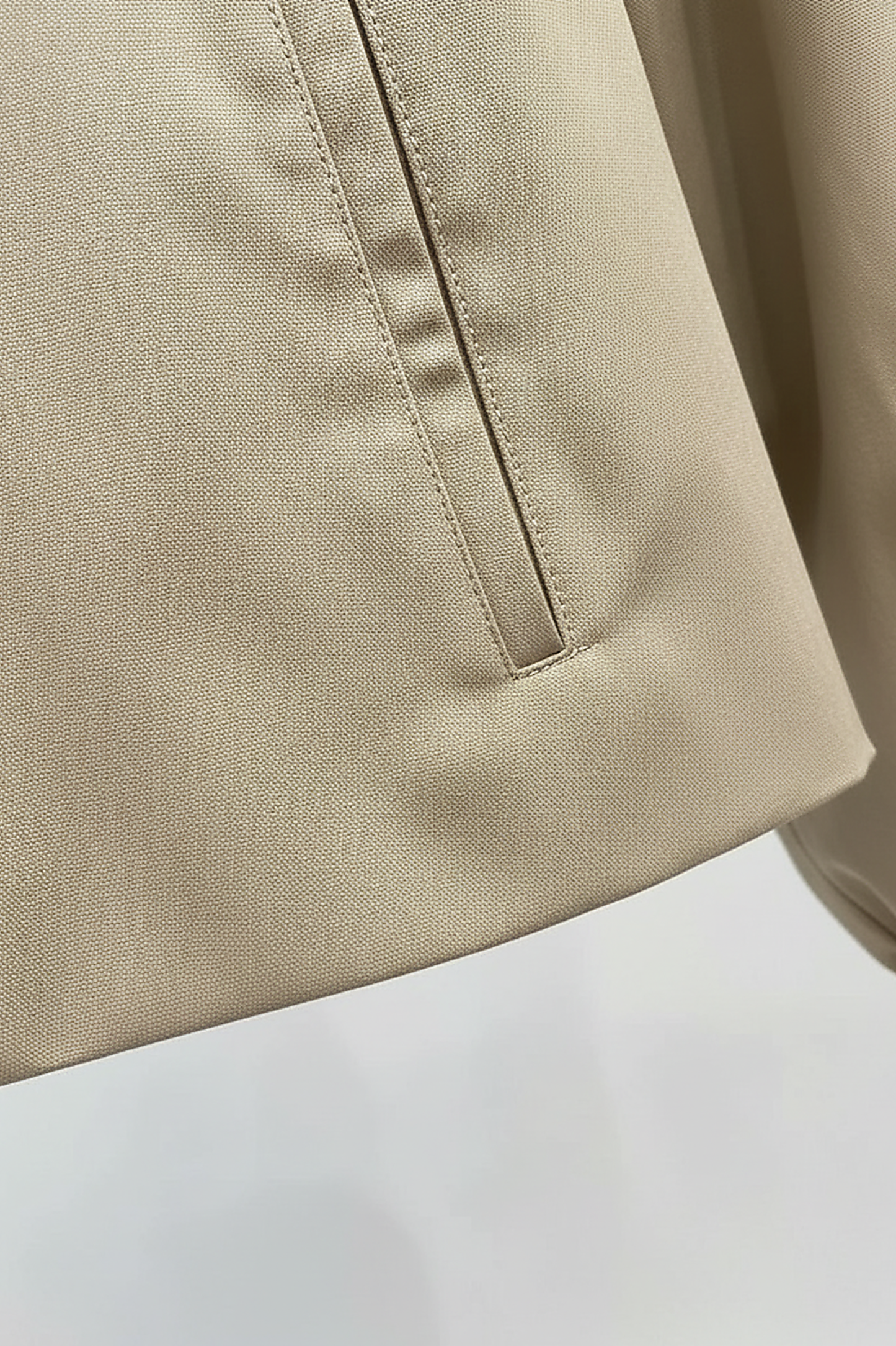 Womens beige trench coat, button closure detail.