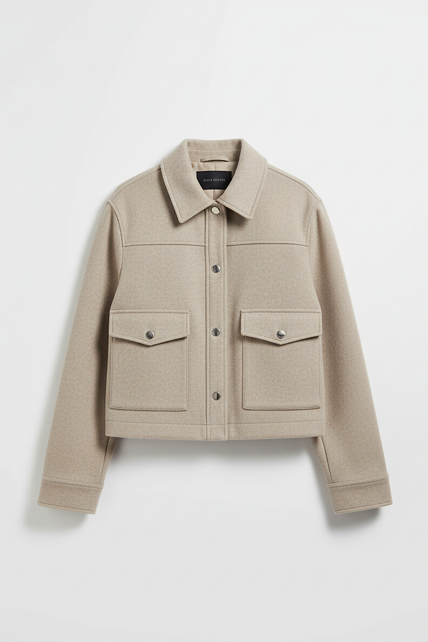 Solid long-sleeve jacket front pocket and button detail.