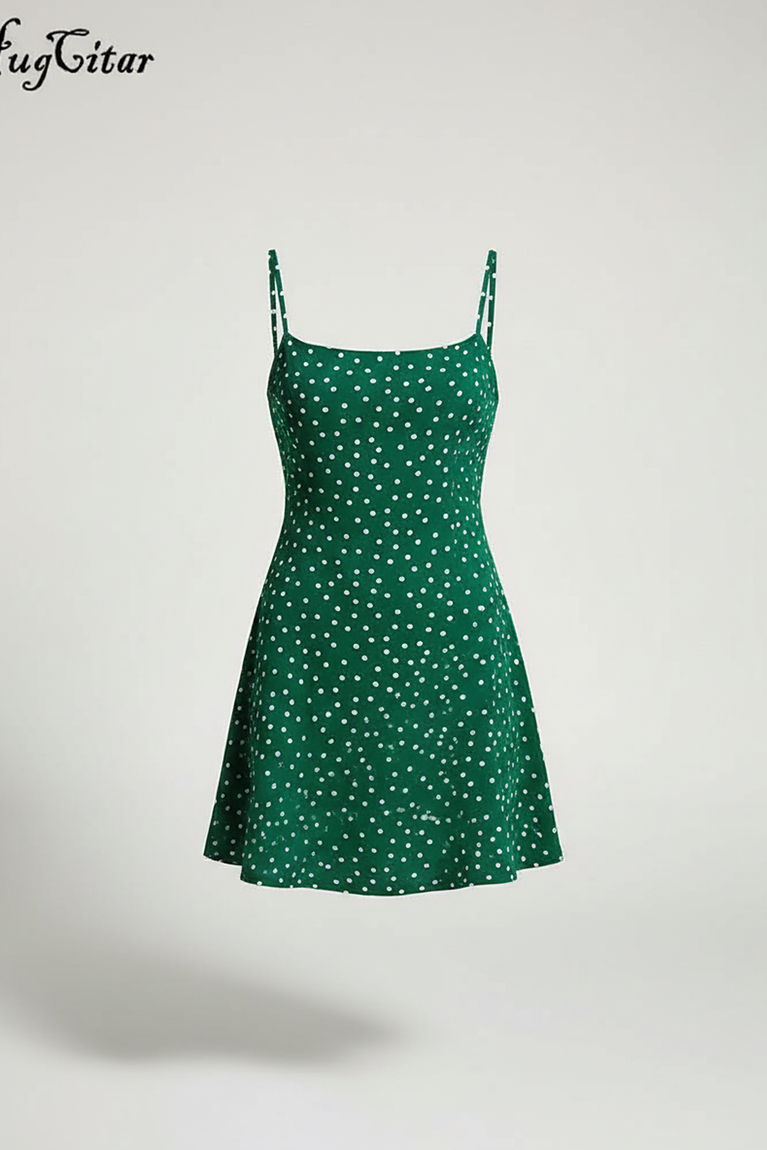 Model looking over her shoulder, wearing a green and white polka dot spaghetti strap mini dress.; Front view of a model with her hands clasped, wearing a green polka dot slip dress against a white