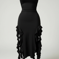 Front view of a model wearing a black strapless bodycon dress with rosette details on the hips and an asymmetrical ruffle hem.; Model wearing the black strapless rosette dress while standing in front