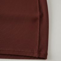 Sleeveless pleated mini dress with high-neck and lace-up, three-quarter view.