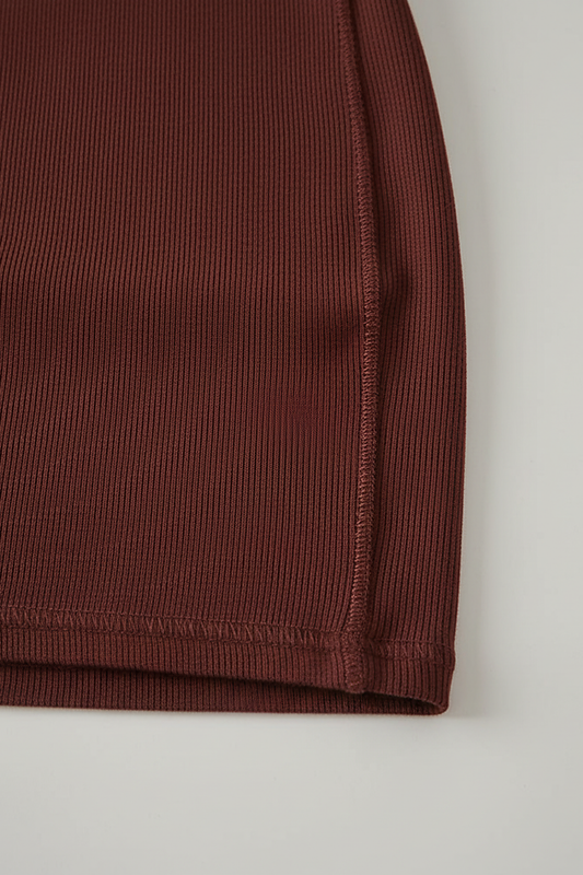 Sleeveless pleated mini dress with high-neck and lace-up, three-quarter view.