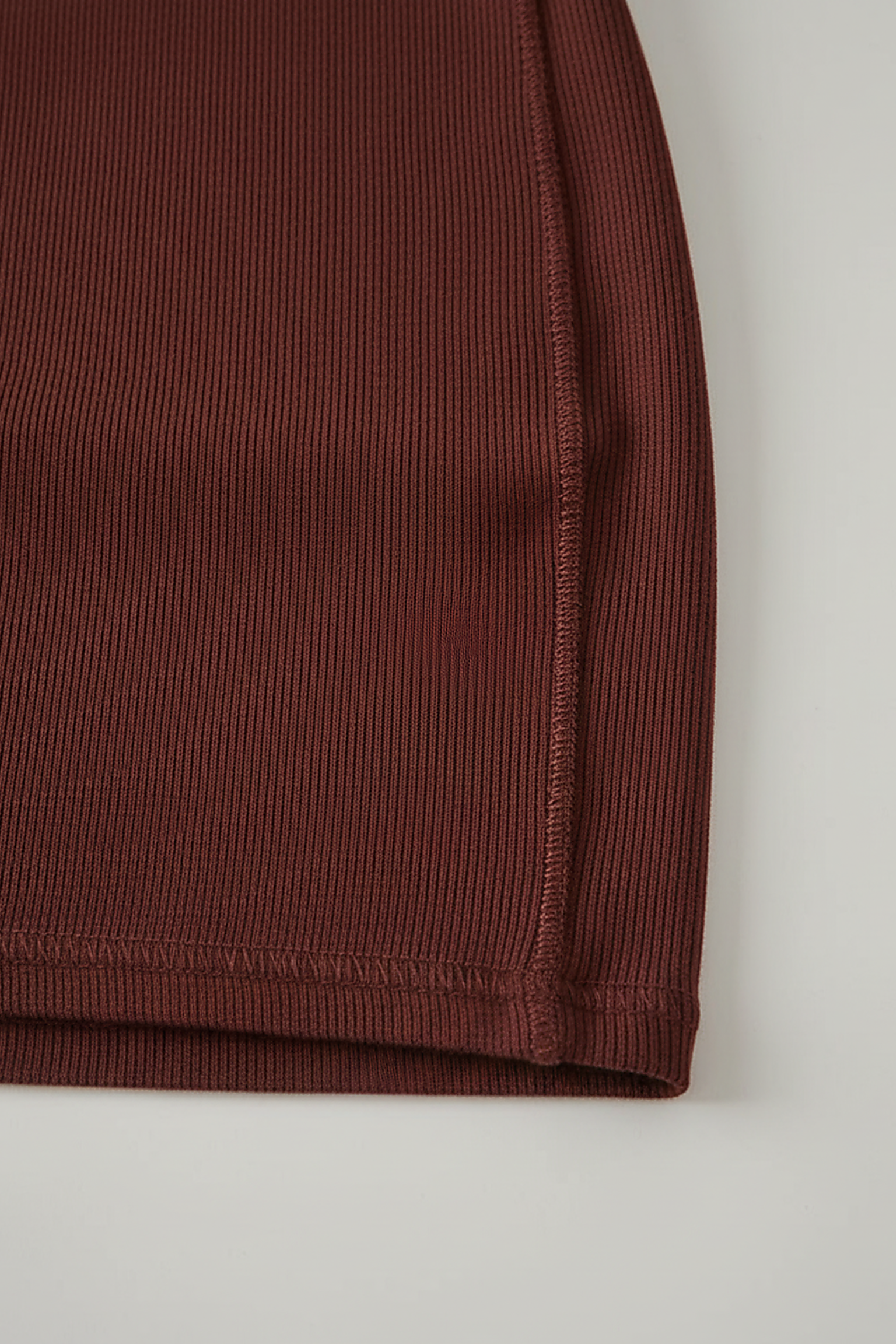 Sleeveless pleated mini dress with high-neck and lace-up, three-quarter view.