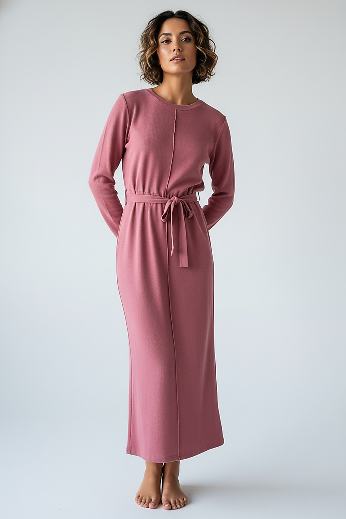 woman wearing a dark plum mini dress, front view, standing, hands relaxed