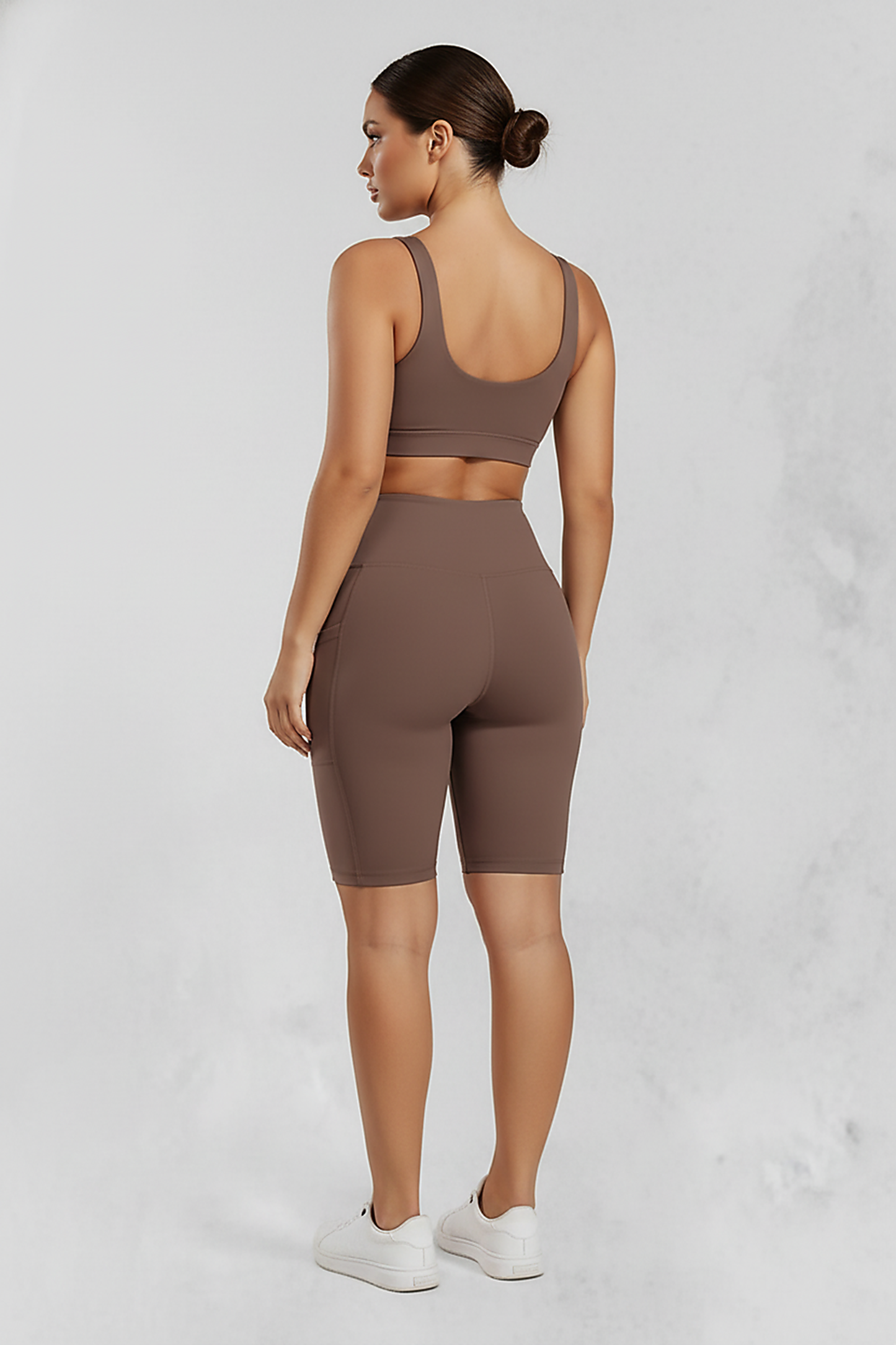 Solid yoga shorts with pockets, back view on model.