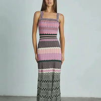 Black sleeveless knitted dress, model walking pose.