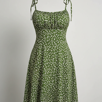 Model with hand on hip wearing a green floral tie-shoulder mini dress against a white background.; Full-length studio shot of a model wearing a green floral spaghetti strap sundress.; Model adjusting