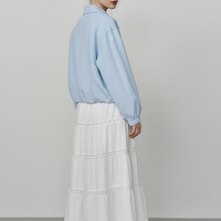 Beige short jacket, side view on model.