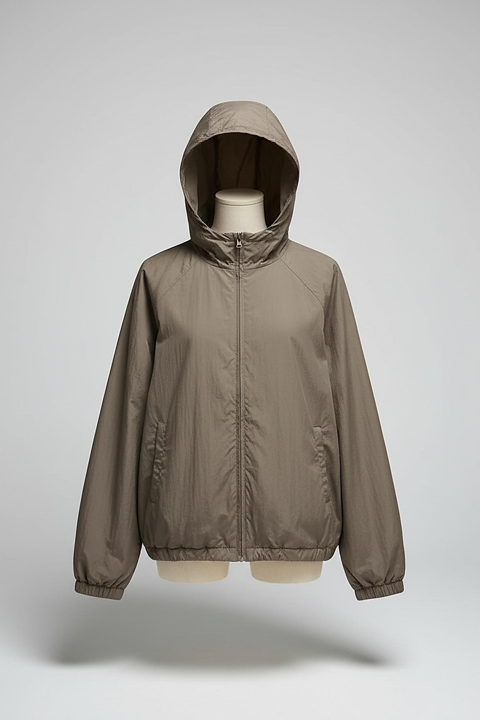 Orange transparent hooded jacket, model posing outdoors.