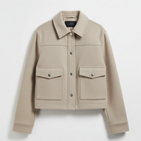 Solid long-sleeve jacket front pocket and button detail.