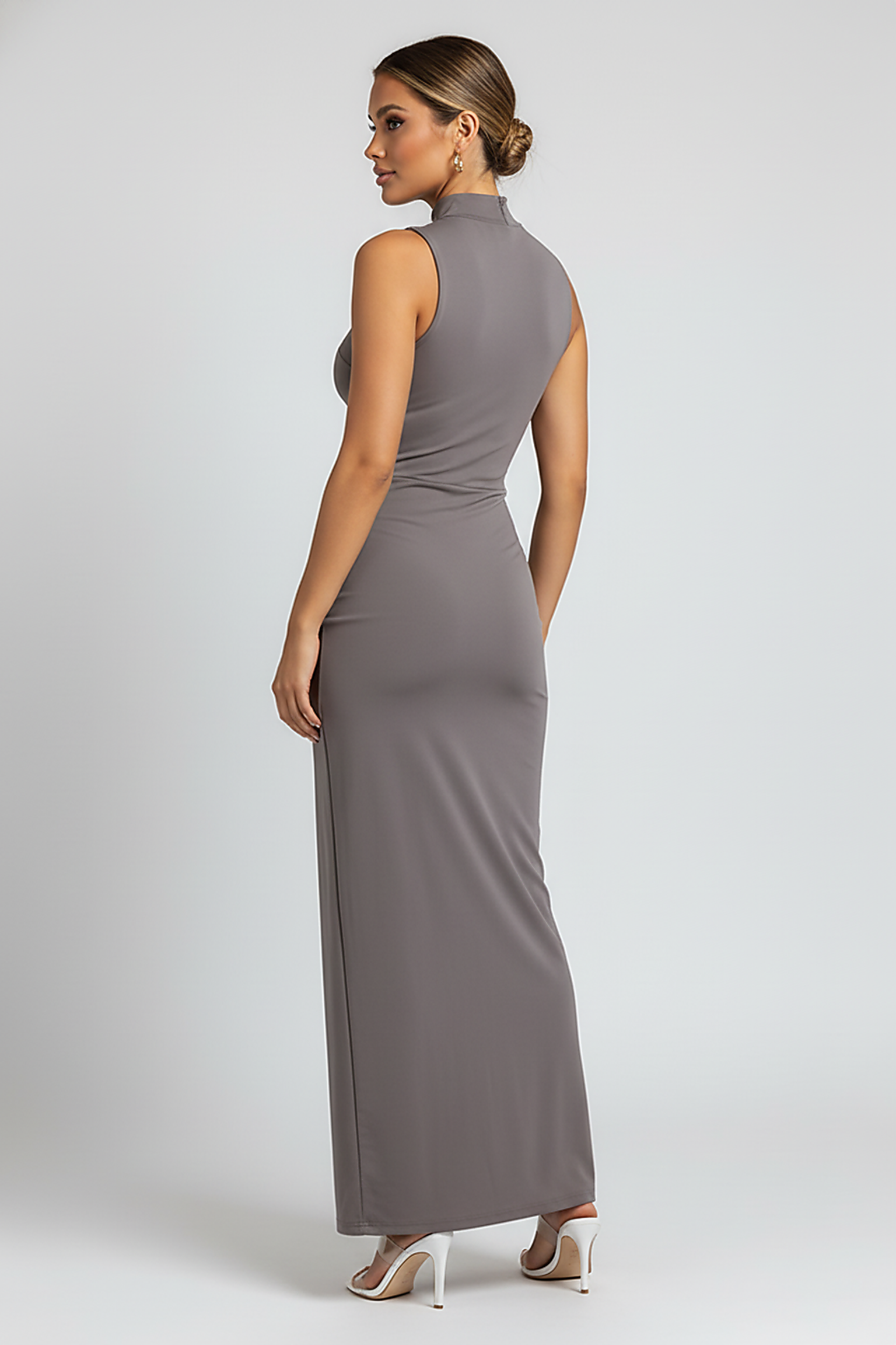 White elegant sleeveless high-slit turtleneck maxi dress, on model.