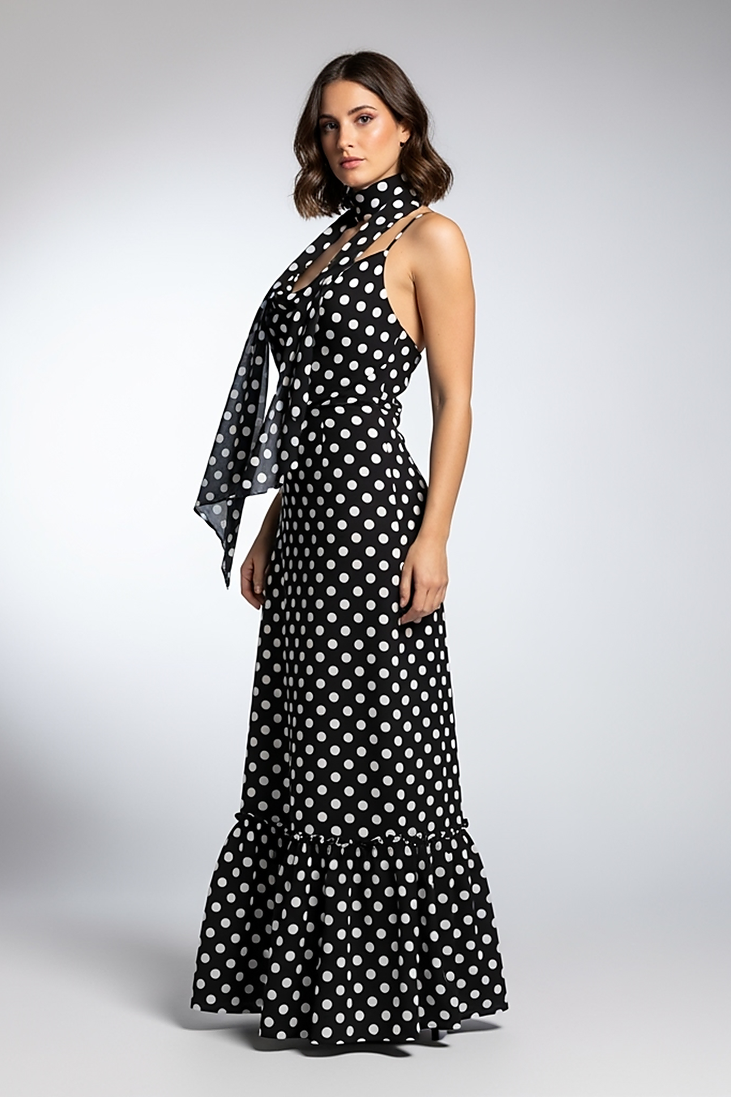 woman wearing white polka dot maxi dress, front view, standing, hands relaxed