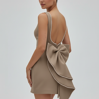 White mini dress with backless design, side view on model.