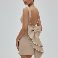 White mini dress, pearl bow detail, front view on model.