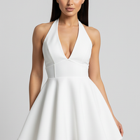 Halter V-neck pleated mini dress, half body view on smiling model.